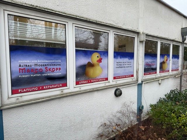 Ein Gebäude mit einem großen Fenster, geschmückt mit einer Badewannenente